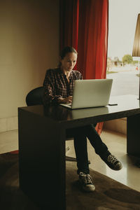 Mid adult woman working on laptop while sitting in office