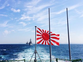 Japanese flag on boat at sea against sky
