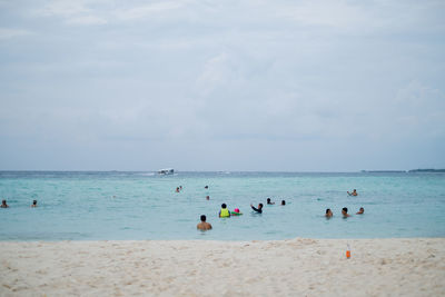 People on beach against sky