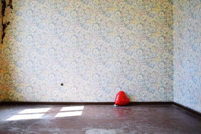 Person standing on red floor against wall