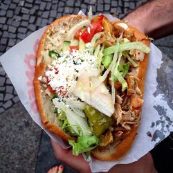 Cropped image of hand holding chicken kebab with bread