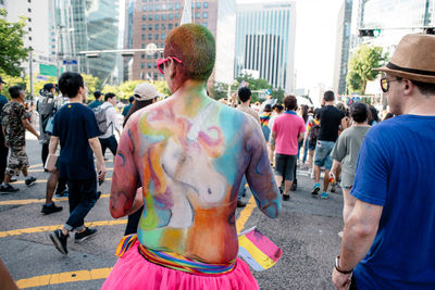 Rear view of people walking on street in city