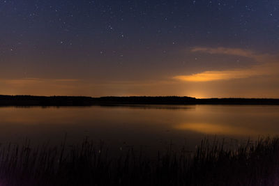 Scenic view of lake against sky at sunset