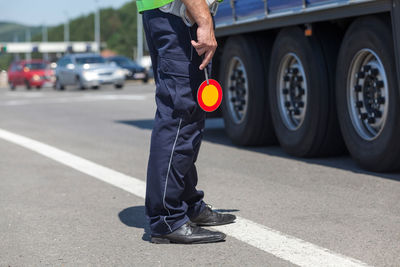 Low section of man holding sign on road