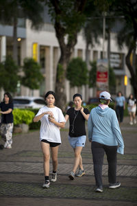 Rear view of siblings walking on street