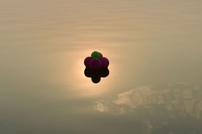 Silhouette of balloons against sky during sunset