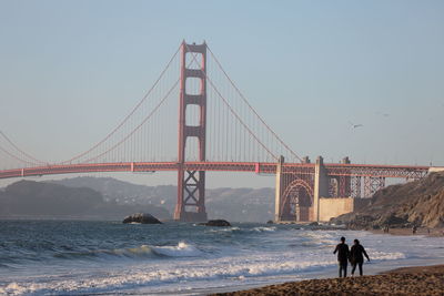 Golden gate bridge over sea against clear sky