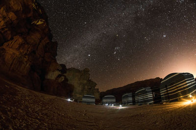 Illuminated rock formation against sky at night