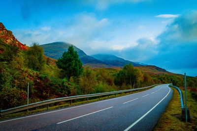 Road by mountain against sky