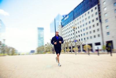Full length of man running on city street