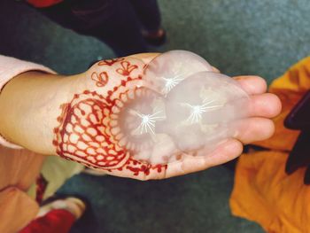 Cropped hand of woman holding artificial jellyfish on road