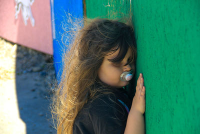 Portrait of cute girl against blue wall