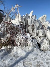Low angle view of icicles on snow covered land against sky
