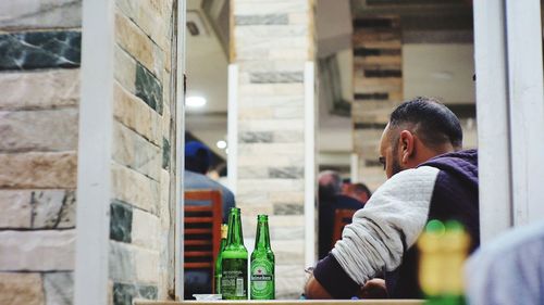 Rear view of man looking up while sitting outdoors