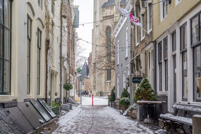 Empty road amidst buildings in city