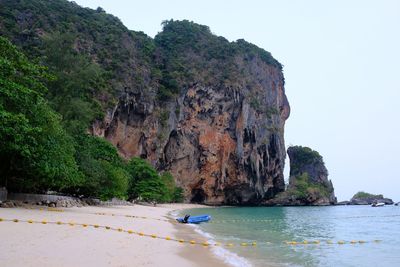 Scenic view of rocks by sea against sky