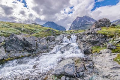 Scenic view of waterfall against sky