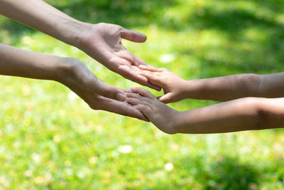 Cropped image of man holding hands against blurred background