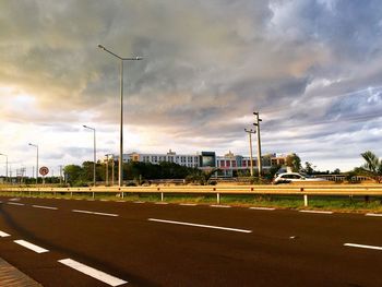 Road in city against cloudy sky