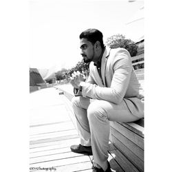 Young man looking away while standing on table