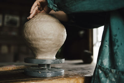 Female potter making vase in workshop