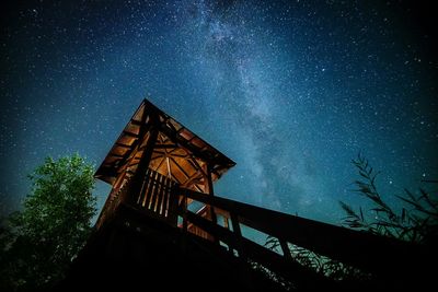 Low angle view of lookout tower against star field at night