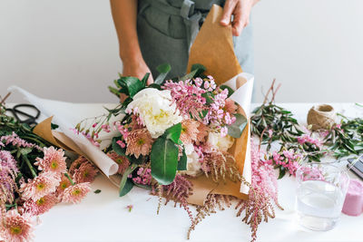 A flower boutique employee creates a flower arrangement.