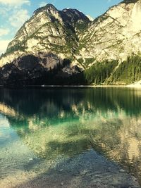 Scenic view of lake by mountains against sky