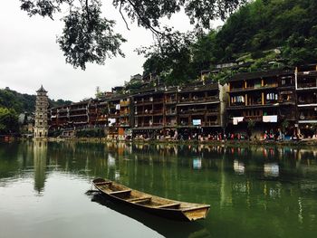 Scenic view of lake by buildings against sky