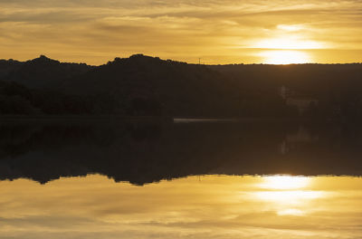 Scenic view of lake against orange sky during sunset