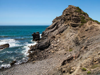 Rock formation on beach against clear sky