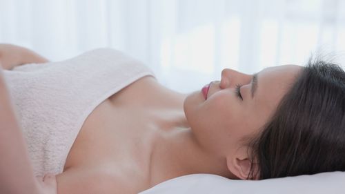 Young woman lying on bed at home