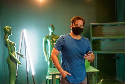 Full length of young man standing against illuminated light