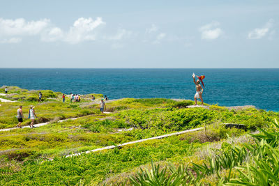 Rear view of man standing on beach against sky