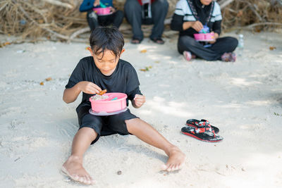 Child eating from lunch box when picnic at the beach.