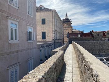 Footpath amidst buildings in city