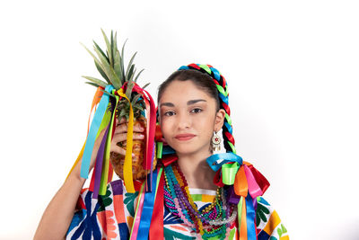 Portrait of young woman with multi colored hair against white background