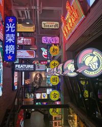 Low angle view of illuminated signs in city at night