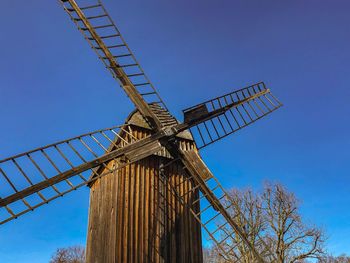 Low angle view of traditional windmill against clear blue sky