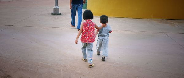 Rear view of friends walking on floor