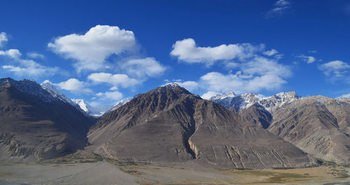 Scenic view of snowcapped mountain against cloudy sky