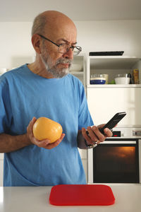 Portrait of senior man using digital tablet at home