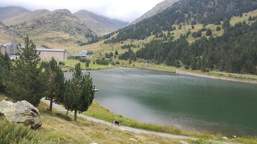 Scenic view of river by mountains against sky