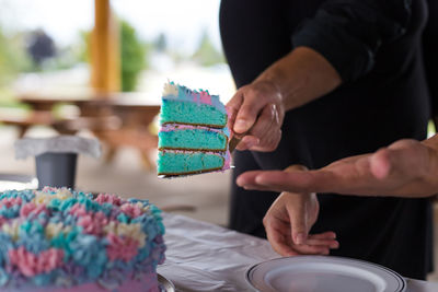 Midsection of person with chocolate cake on table