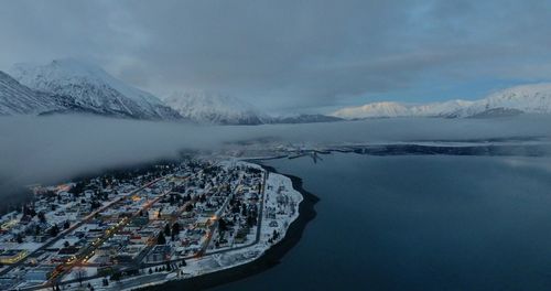 Scenic view of lake by snowcapped mountains against sky