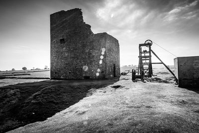 Old building by sea against sky