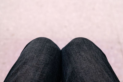 Low section of person standing against black background