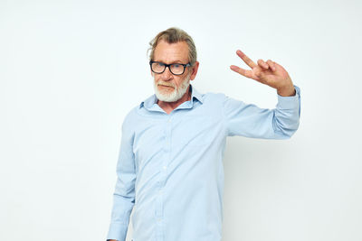 Senior man gesturing against white background