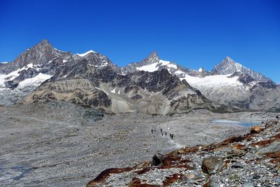 Scenic view of snowcapped mountains against clear blue sky