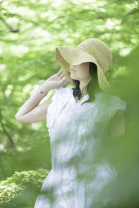 Woman holding umbrella on field
